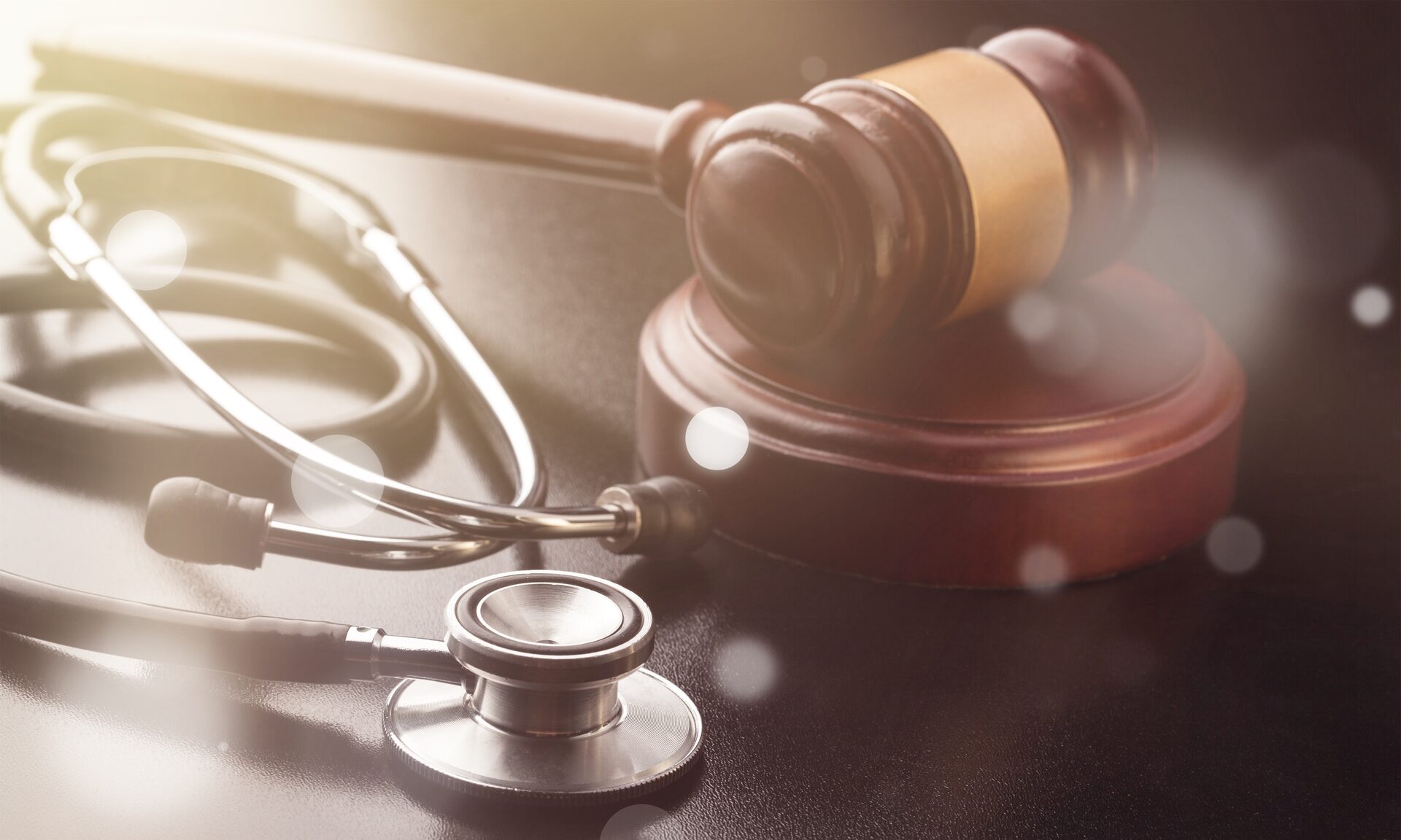 A stethoscope and gavel resting on a desk